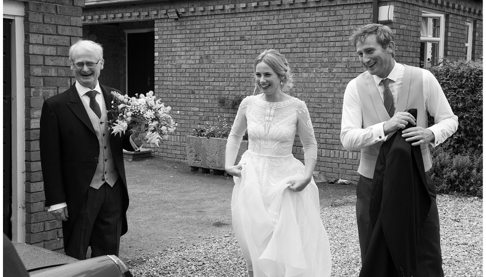 The bride, her father and her brother outside.