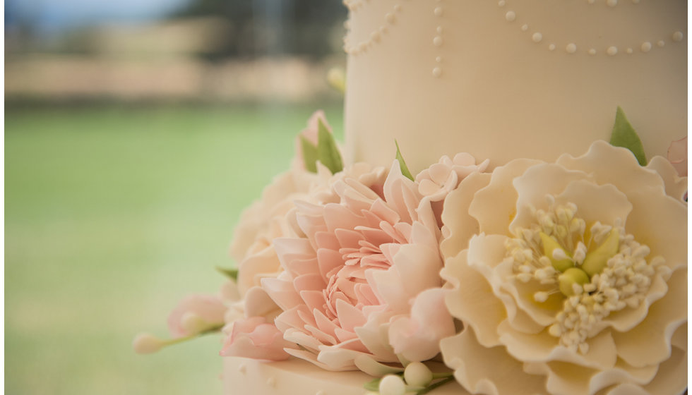 Wedding cake ornately decorated with flowers.