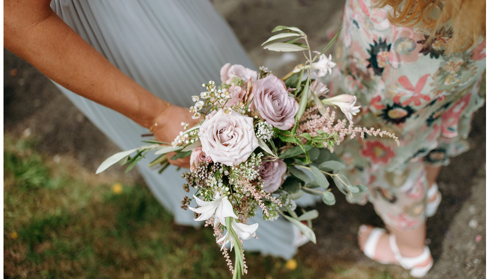 One of the bridesmaid's holding a bouquet.
