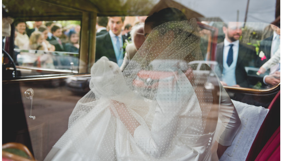The bride in her car showing her polka dot veil. 