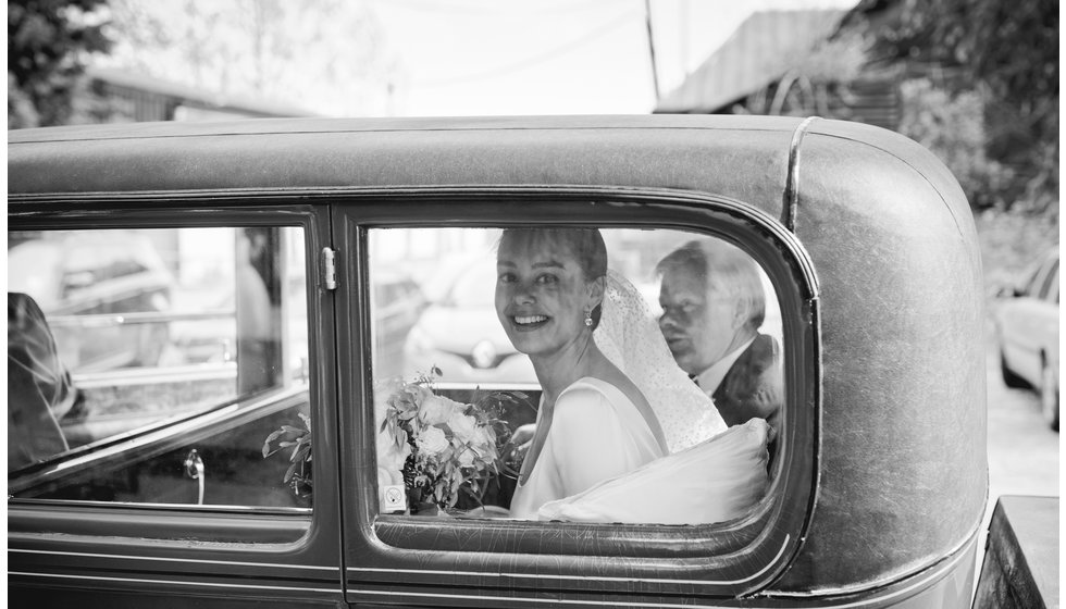 The bride arriving to the church in a vintage car with her father.