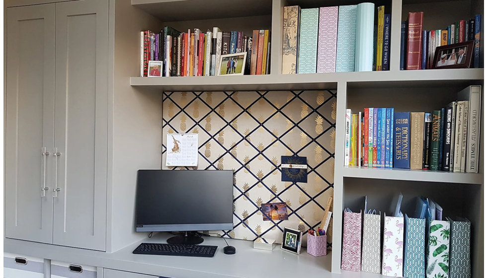 Image of desk space with notice board behind computer.