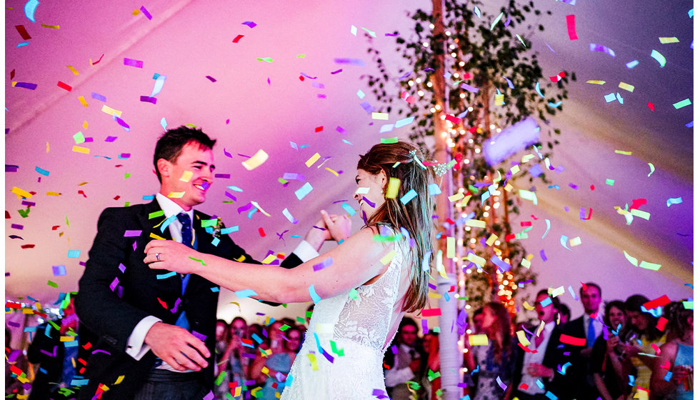 Confetti falling over the bride and groom performing their first dance.