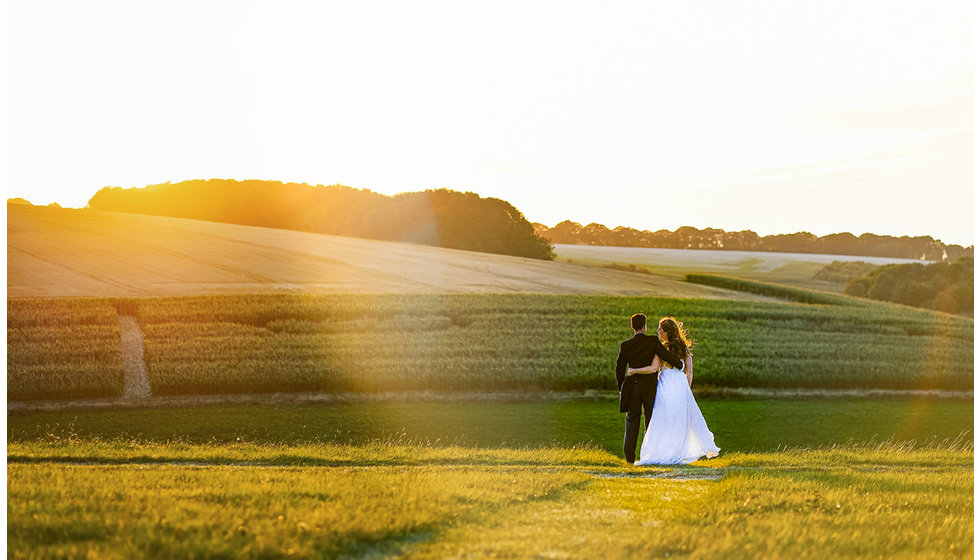 The bride and groom take a walk in beautiful surrounding countryside of where their marquee was located in Wiltshire.