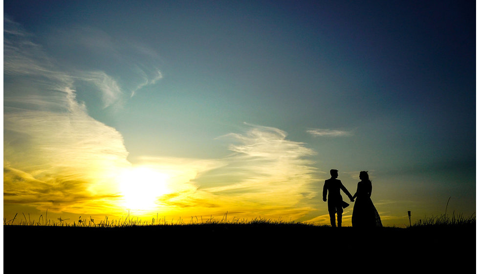 A silhouette of Josh and Victoria in the beautiful valley where their marquee was held with beautiful golden light.