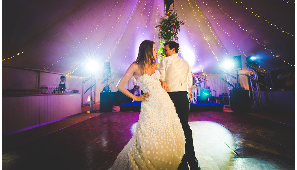 Daisy and Charlie doing their first dance with spotlights illuminating them. 