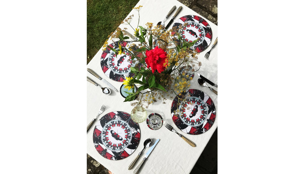 An overhead shot of a table laid for 4 people with Bell's red butterfly placemats.