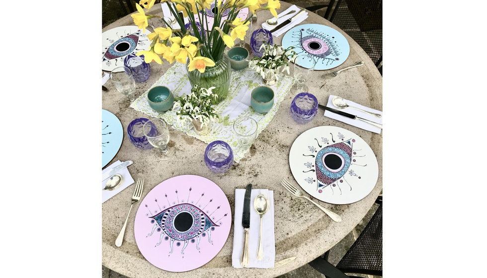 A tablescape outdoors with the eye placemats at the centre.
