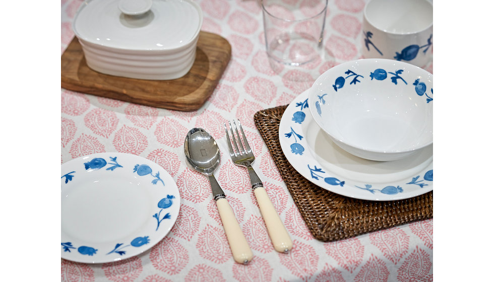 A block printed tablecloth by Sarah K, Alice Peto Rose Hip plates, OKA rattan placemats and cap deco ivory cutlery.