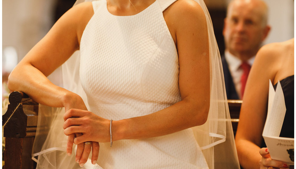 The brides dress with a close up of a diamond bracelet. 
