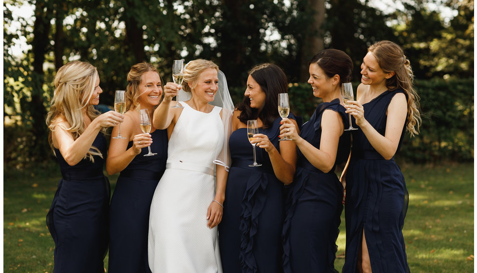 The bridesmaids all wearing blue off the shoulder dresses.