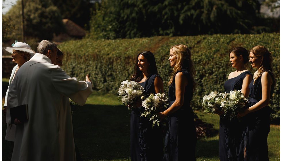 The bridesmaids being welcomed by the vicar before they go into the Church.