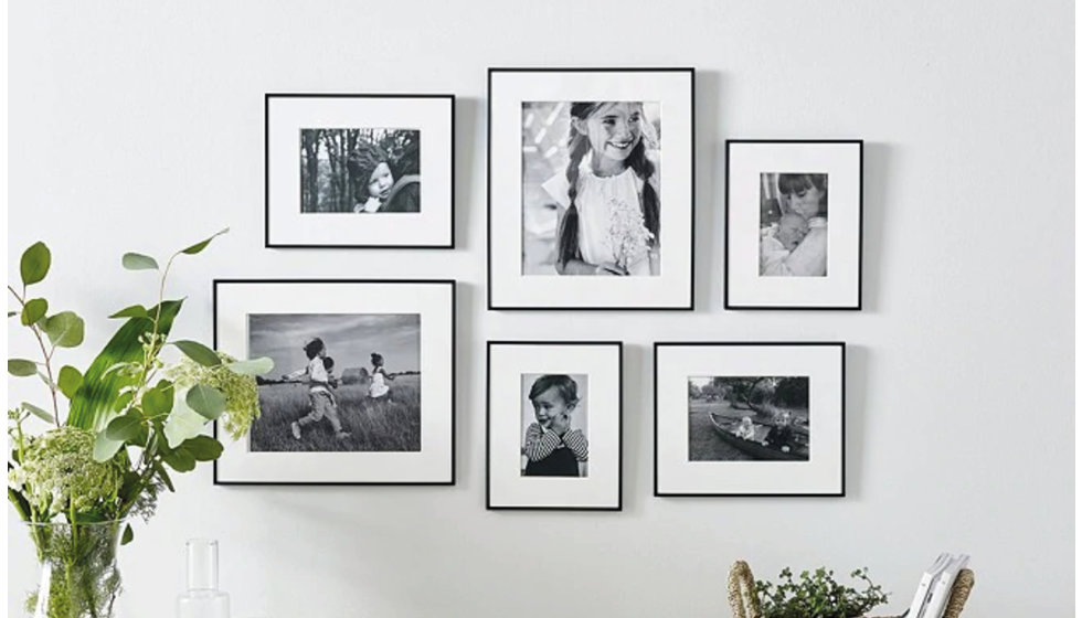 A gallery wall of black and white photos, all with black frames.