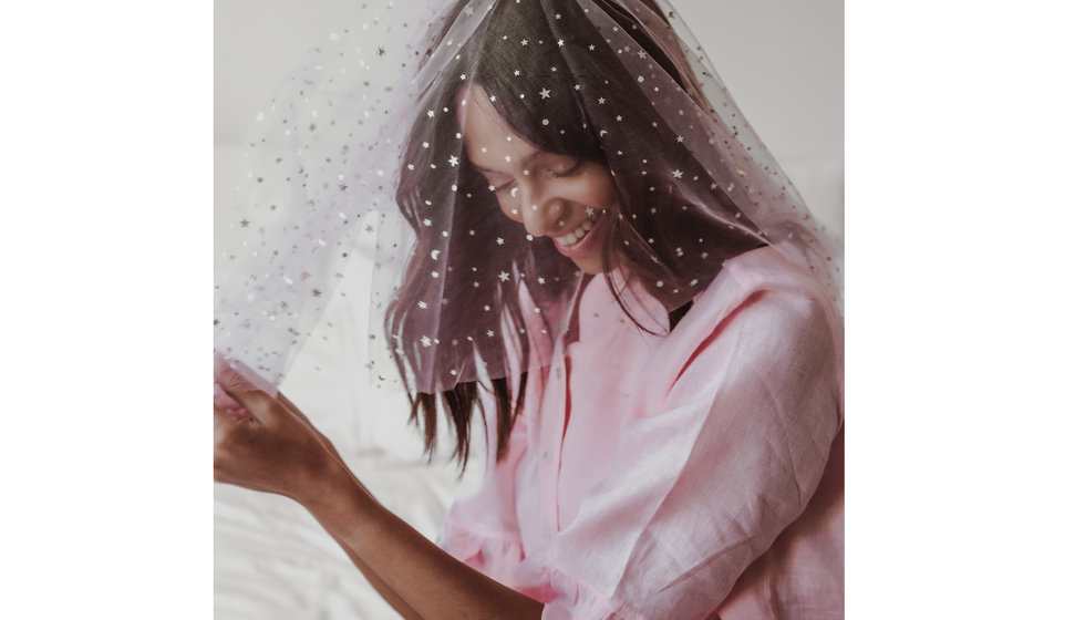 A girl in pink pyjamas wearing a Gigi and Olive Star veil.