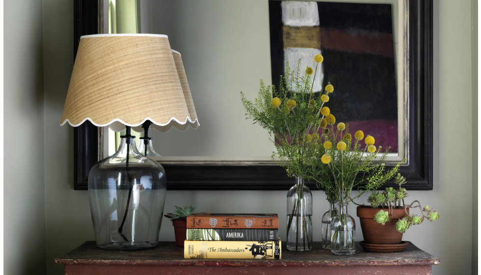 An image of a side table with a lamp and books.