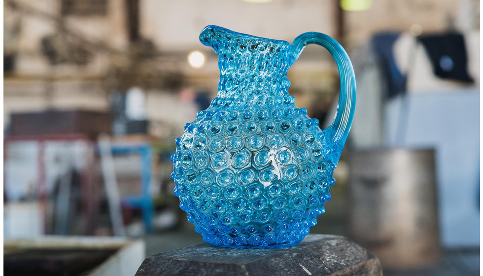 A blue hobnail jug in the factory.