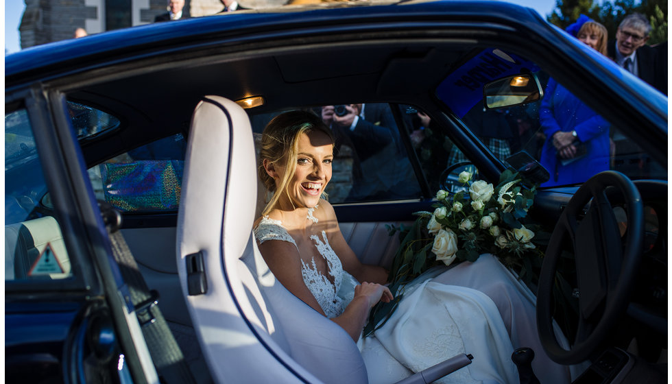 The bride sitting in the car.