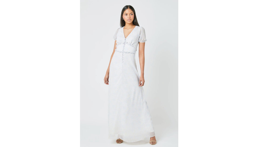 A v neck short sleeve maxi bridesmaids dress. The fabric has a faded floral pattern on it and a ruffle at the waste and buttons by Maids to Measure.
