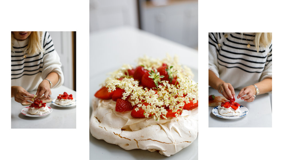 A delicious pavlova decorated with fresh strawberries and fresh elderflower. 