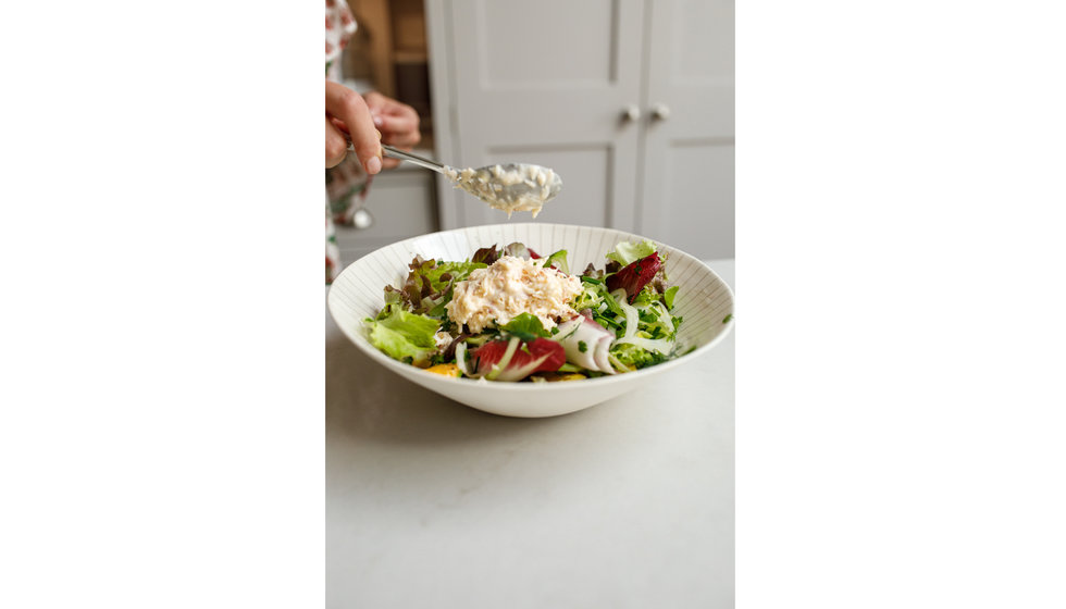 A large bowl of rustic salad leaves and fresh crab.
