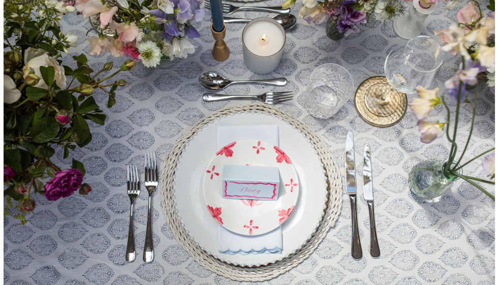 A tablescape featuring Penny Morrison's pink Summer starter plate paired with a Costa Nova Pearl Dinner plate and a Sarah K block print tablecloth.