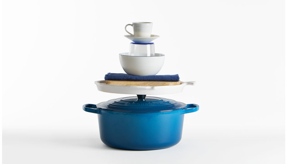 A blue stack of presents with a Le Creuset cast iron casserole as the base.