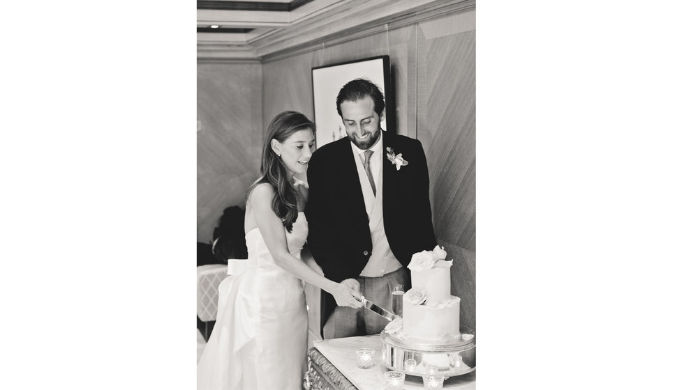 The bride and groom cut their cake in the Connaught hotel.