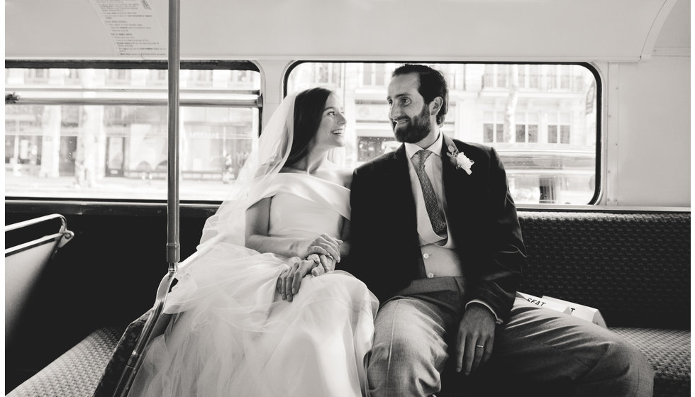 The bride and groom on an old London Bus to transport them and the guests to the venue.