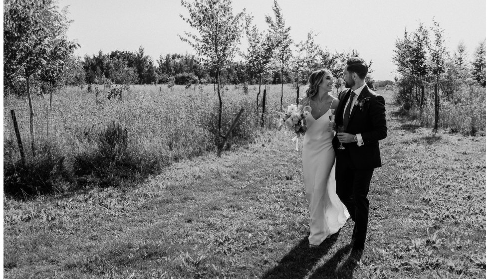 Louise and Matthew walking through the countryside on their wedding day.