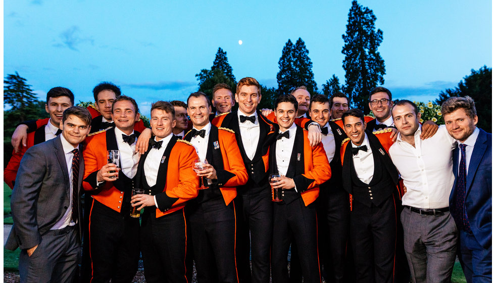 The groom and his friends all wearing their military dress uniform. 