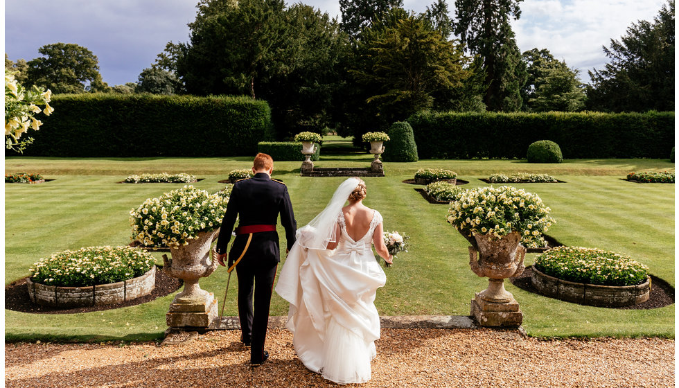 Charlotte and Matthew outside their wedding venue in the grounds on a summers day. 