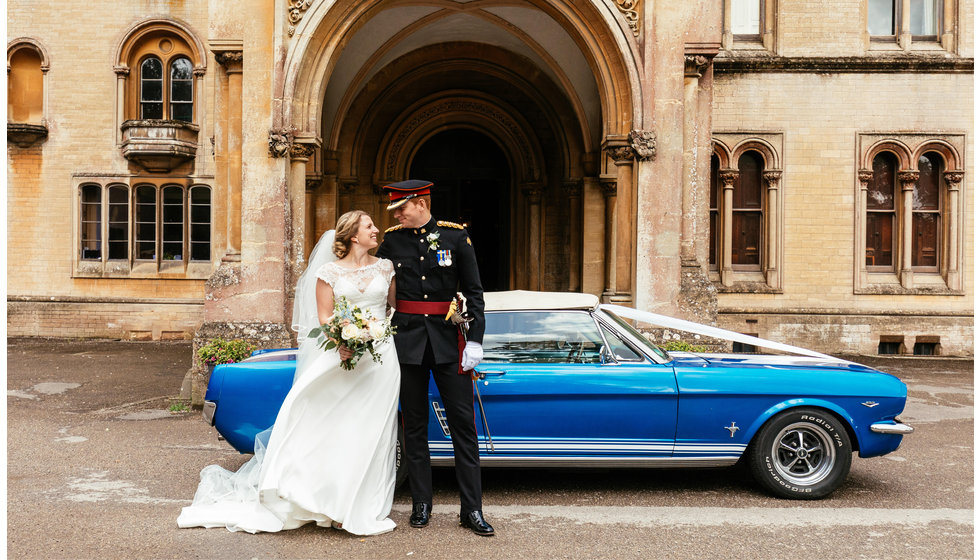 Charlotte and Matthew outside their wedding venue and outside their traditional wedding car - a ford focus.