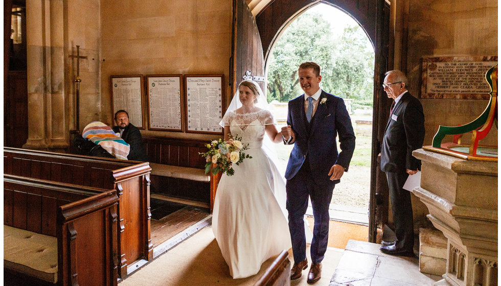 The bride walking down the aisle with her brother in their Wiltshire Church.