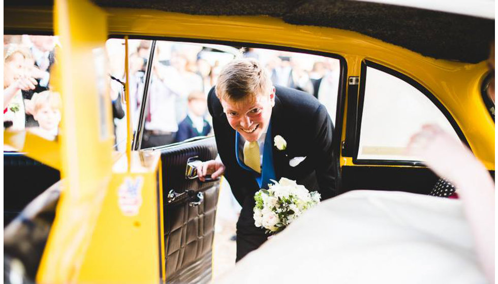 The groom getting into the back of a nyc yellow cab. 