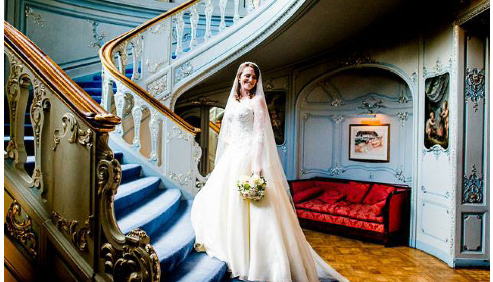 The bride standing on the stairs of the Saville Club where they had their wedding reception.