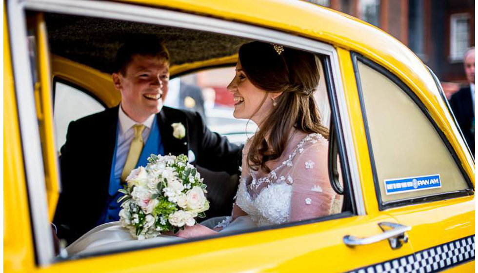 The bride and groom in the back of a NYC yellow cab outside the Royal Hospital in Chelsea before driving to their reception at the Savile Club. 