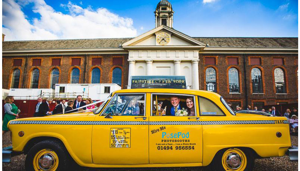 The bride and groom in an NYC yellow cab outside the Royal Hospital Chelsea in London.