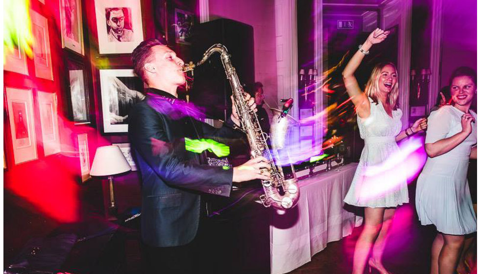 A saxophonist playing live for the bride and groom's wedding reception at the Savile Club.