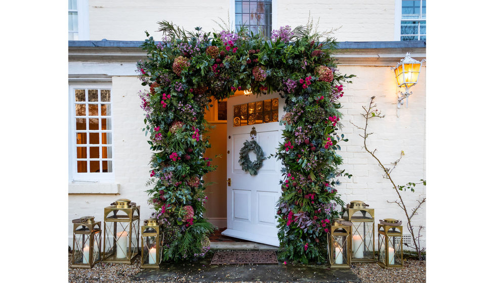 Edwina's family home with a floral arch, a festive wreath and some lanterns.