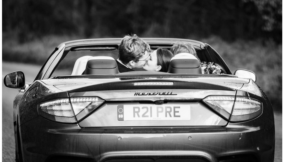 Edwina and Edward share a kiss in a convertible sports care on the way back from the Church.