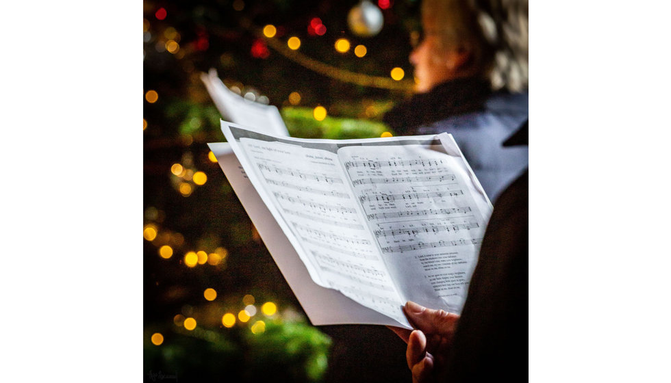 A lovely image of a hymn book with a Christmas tree in the background.