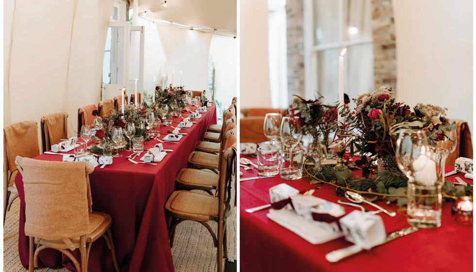 Details on the wedding breakfast table include a deep red linen tablecloth, crackers, winter florals and lots of candlesticks. 