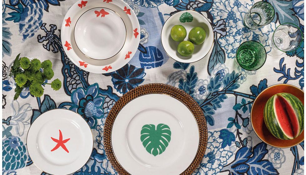 A fun and quirky tablescape using china from Alice Peto's tropical collection on top of a printed blue and white floral tablescape.