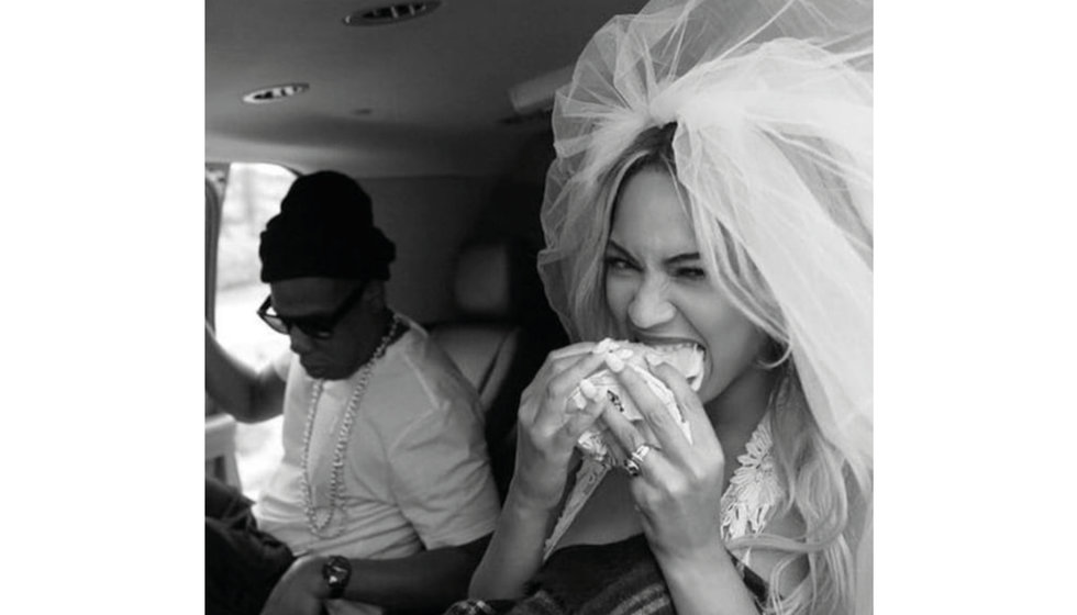Beyonce eats a burger wearing a veil in the back of a car with JZ.
