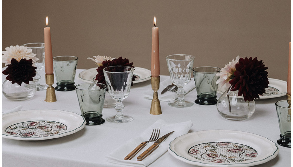 A chic tablescape with a white tablescape with Gien dinner plates.