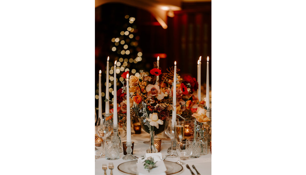 A close up of Sophie and Graeme's wedding table laid with candles and winter flowers.