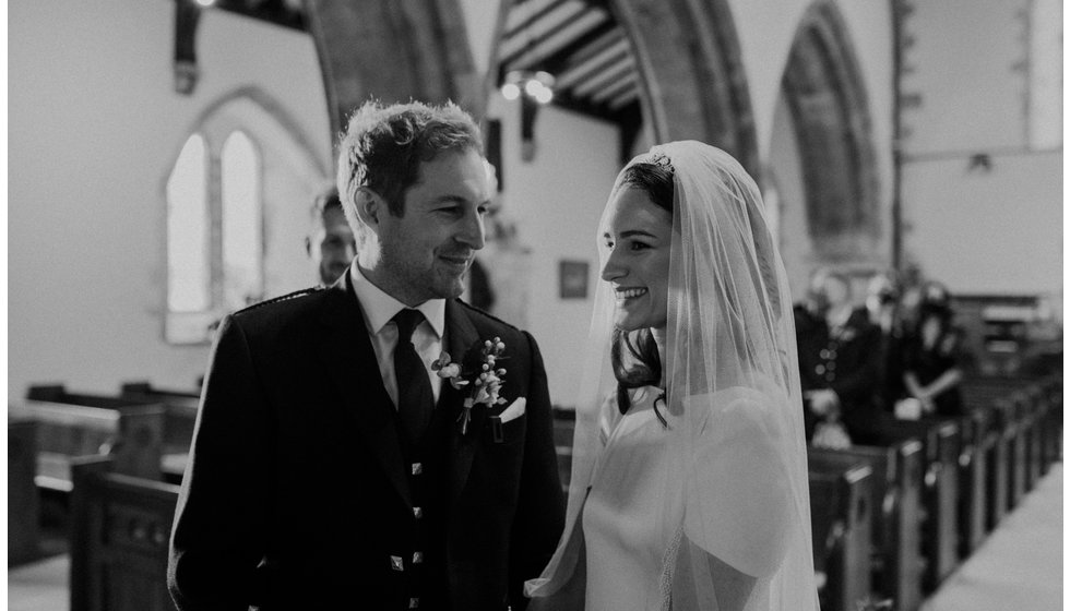 Sophie and Graeme smile during their intimate Church wedding in Hampshire.