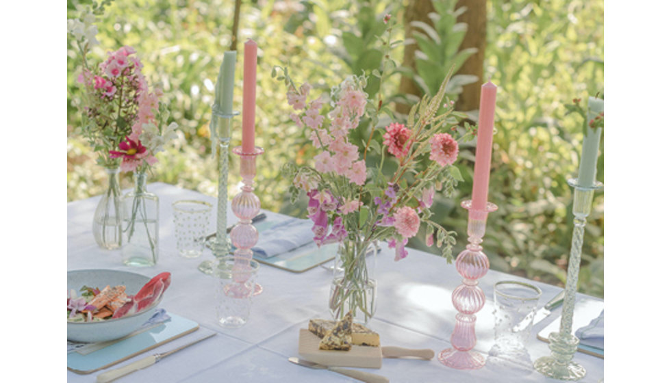A table outside with Issy Granger colourful glass candlesticks. 
