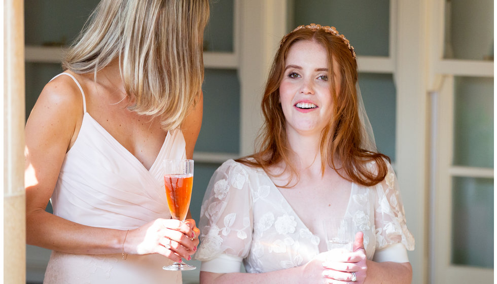 Sarah and a bridesmaid drinking champagne.