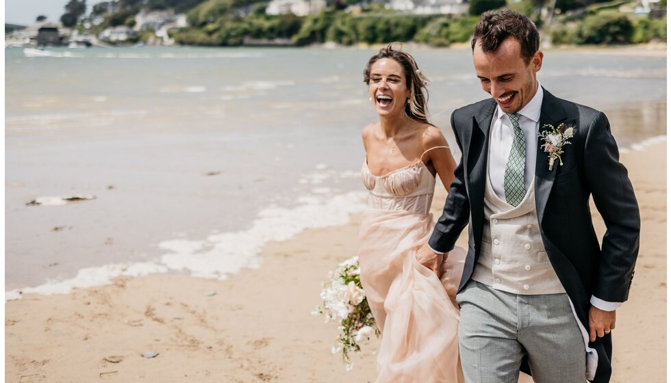 Chloe & Ed take a walk along Rock Beach, Cornwall after their wedding ceremony